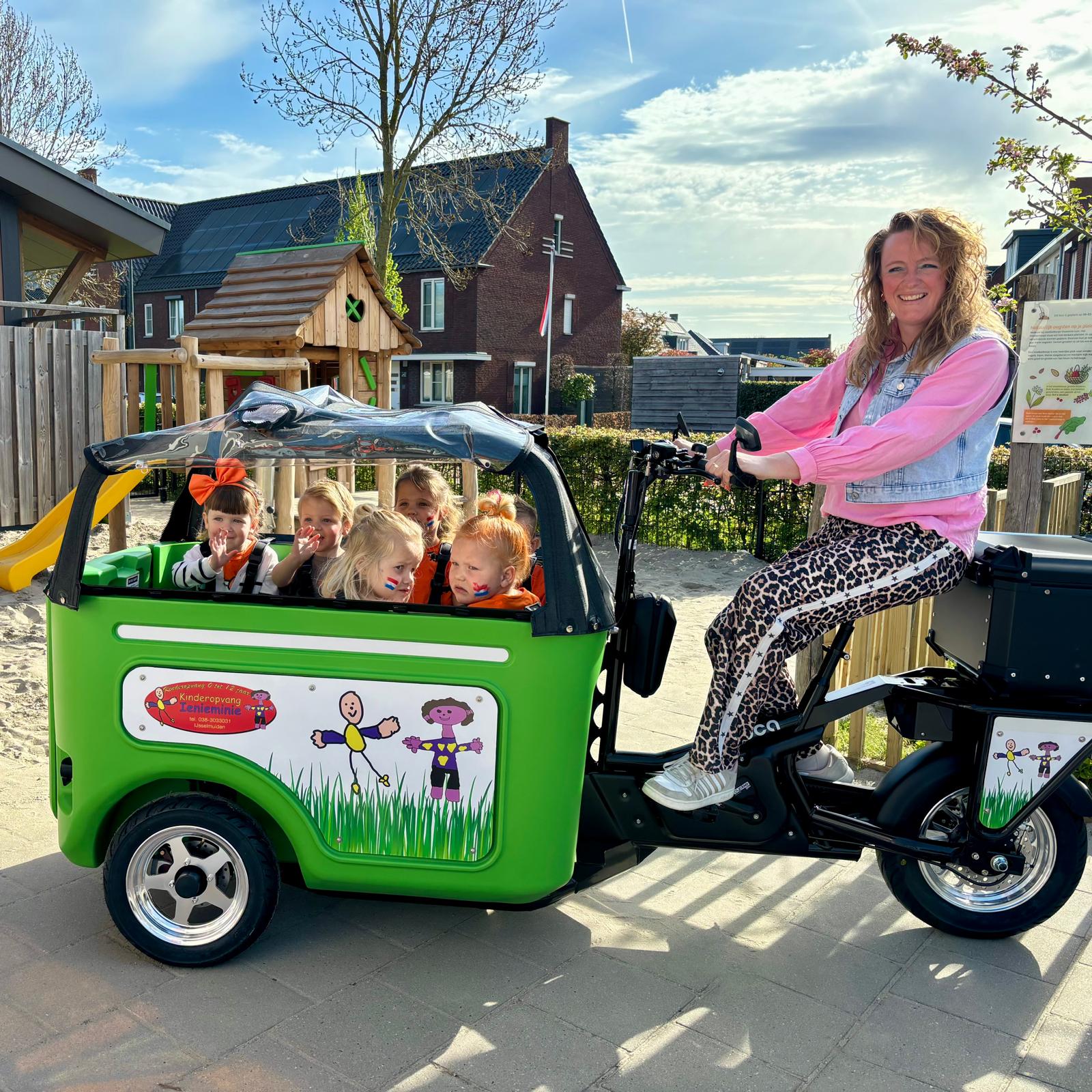 Medewerker kinderopvang rijdt op een elektrische bakfiets door de stad